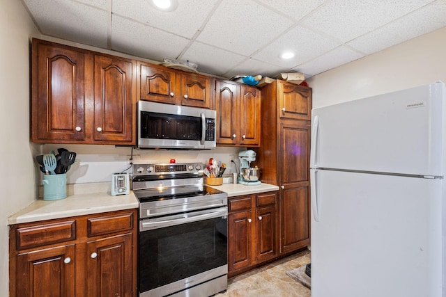 2065 124th Ln NW, Coon Rapids, MN 55448 - kitchen with appliances with stainless steel finishes, light countertops, a paneled ceiling, light stone finish flooring, and recessed lighting
