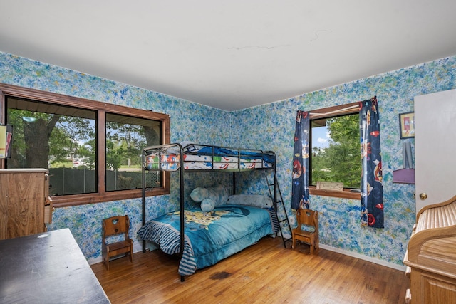 2065 124th Ln NW, Coon Rapids, MN 55448 - bedroom featuring wallpapered walls, wood finished floors, and baseboards