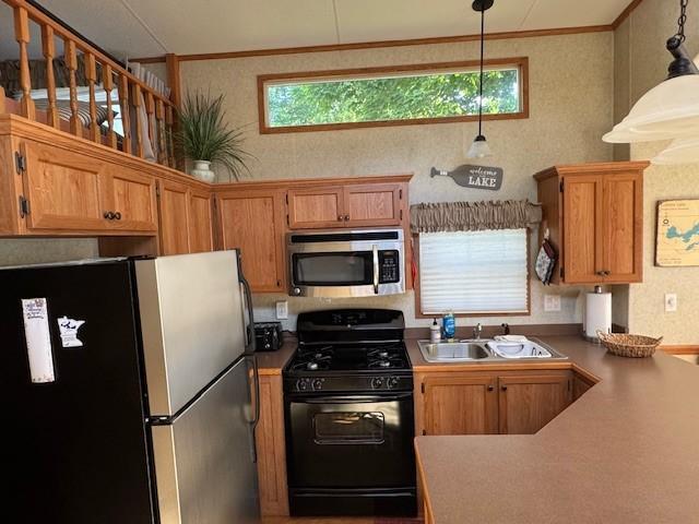 2221 Reubens Ln SW Unit 20, Farwell, MN 56327 - kitchen featuring stainless steel appliances, healthy amount of natural light, ornamental molding, decorative light fixtures, and brown cabinets