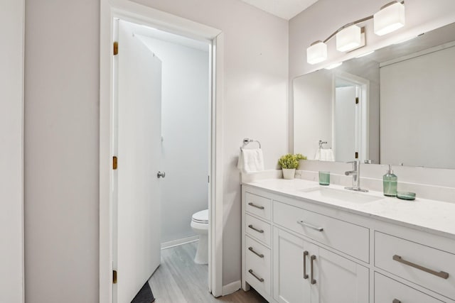 5697 Green Circle Dr Unit 216, Minnetonka, MN 55343 - bathroom featuring toilet, vanity, wood finished floors, and baseboards