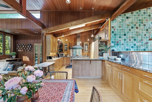 2867 Burnham Blvd, Minneapolis, MN 55416 - kitchen featuring wall chimney range hood, light wood-type flooring, wood walls, light brown cabinetry, and a peninsula