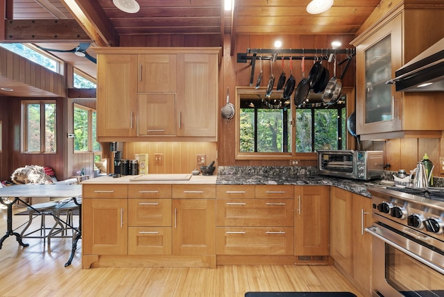 2867 Burnham Blvd, Minneapolis, MN 55416 - kitchen with stainless steel gas range, wooden ceiling, wall chimney exhaust hood, light wood-type flooring, and wooden walls