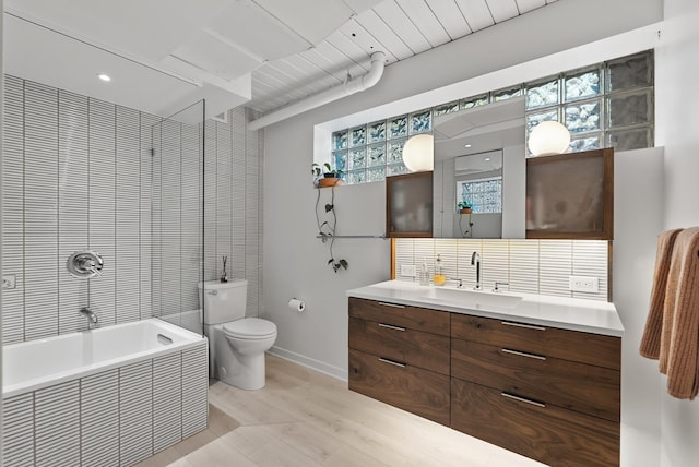 2867 Burnham Blvd, Minneapolis, MN 55416 - bathroom featuring vanity, toilet, a relaxing tiled tub, baseboards, and wood finished floors