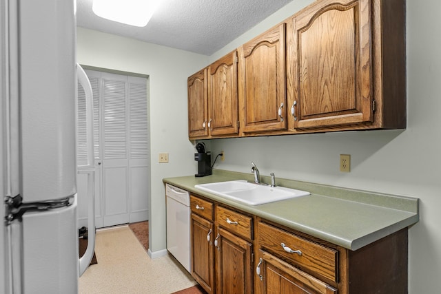 183 Little Canada Rd E Unit 310, Little Canada, MN 55117 - kitchen with white appliances, a sink, light countertops, a textured ceiling, and brown cabinets