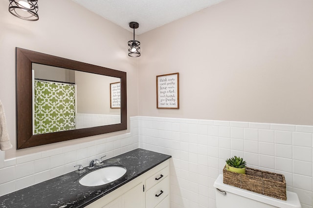 2205 Valders Ave N, Golden Valley, MN 55427 - bathroom with vanity, tile walls, wainscoting, and a textured ceiling