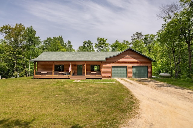 1268 Nellie Lake Ln NE, Longville, MN 56655 - view of front facade featuring driveway, a front lawn, an attached garage, a shingled roof, and covered porch