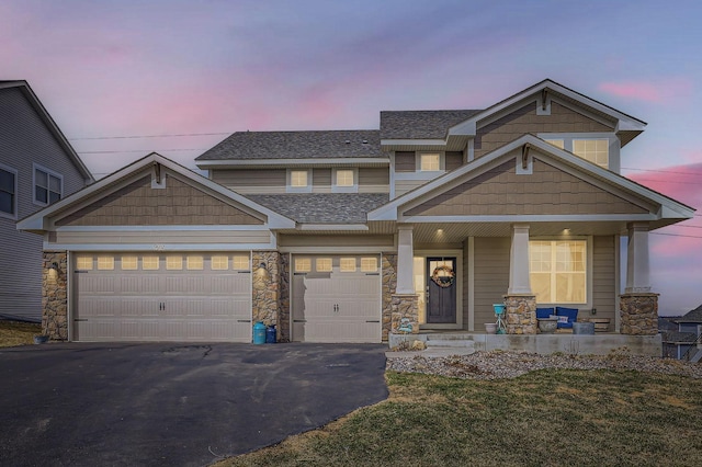 9602 7th St N, Lake Elmo, MN 55042 - view of front of house featuring covered porch, driveway, roof with shingles, a garage, and stone siding