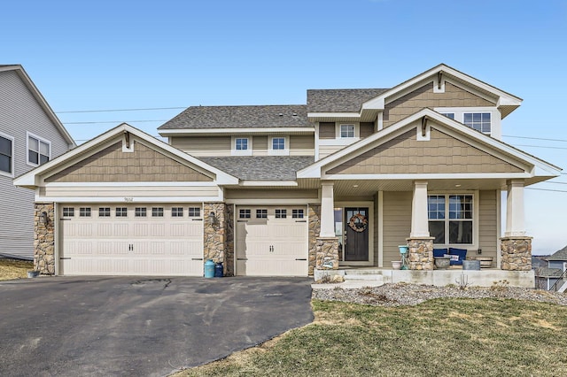 9602 7th St N, Lake Elmo, MN 55042 - view of front of house with a porch, driveway, stone siding, and roof with shingles