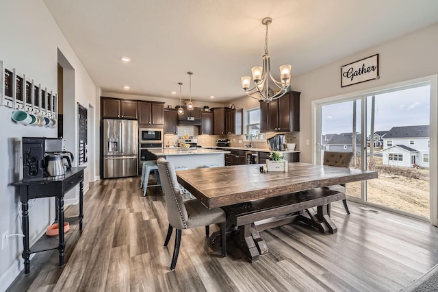 9602 7th St N, Lake Elmo, MN 55042 - dining space with a chandelier, wood finished floors, and recessed lighting