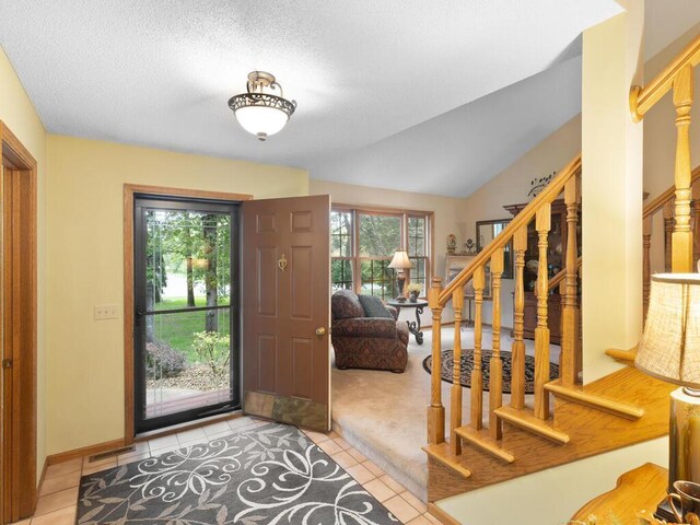 9160 164th Ln NW, Ramsey, MN 55303 - entryway featuring light tile patterned floors, stairway, and lofted ceiling