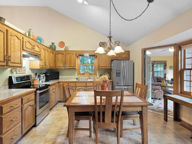 9160 164th Ln NW, Ramsey, MN 55303 - kitchen with stainless steel appliances, under cabinet range hood, light countertops, brown cabinetry, and healthy amount of natural light