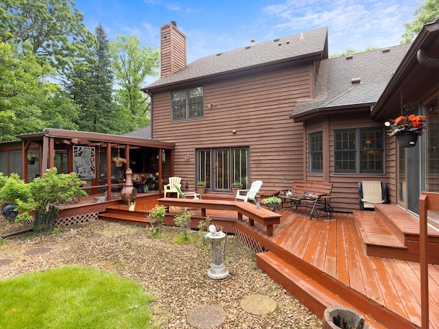 9160 164th Ln NW, Ramsey, MN 55303 - rear view of house featuring a chimney, a shingled roof, a deck, and a sunroom