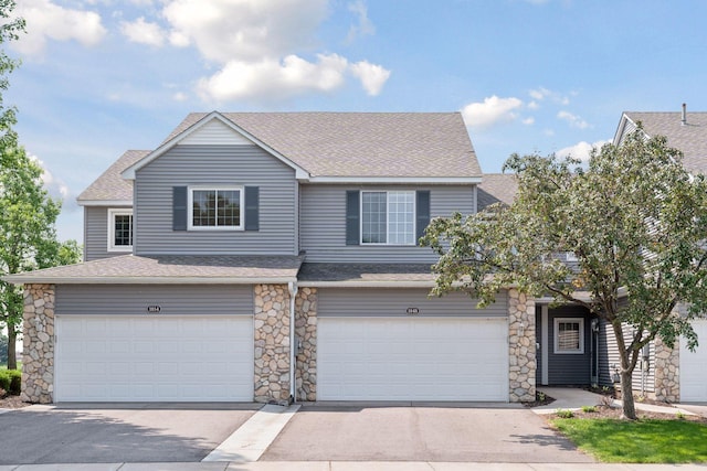 1848 111th Ave NE, Blaine, MN 55449 - view of front of home featuring an attached garage, a shingled roof, stone siding, and concrete driveway