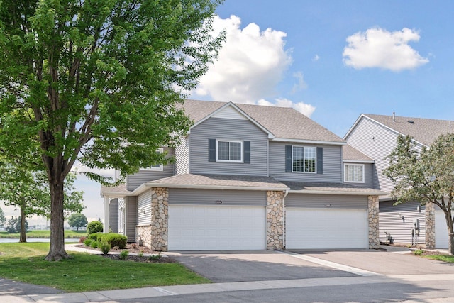 1848 111th Ave NE, Blaine, MN 55449 - view of front of home featuring stone siding, roof with shingles, a garage, asphalt driveway, and a front yard