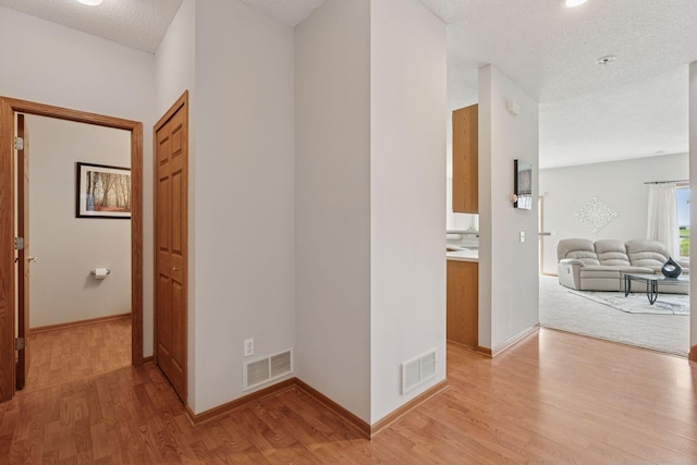 1848 111th Ave NE, Blaine, MN 55449 - hall featuring light wood finished floors, baseboards, and a textured ceiling