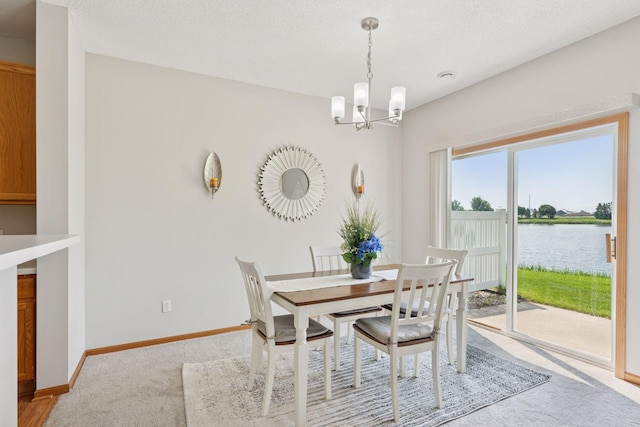 1848 111th Ave NE, Blaine, MN 55449 - dining room with a chandelier, light carpet, a water view, and baseboards