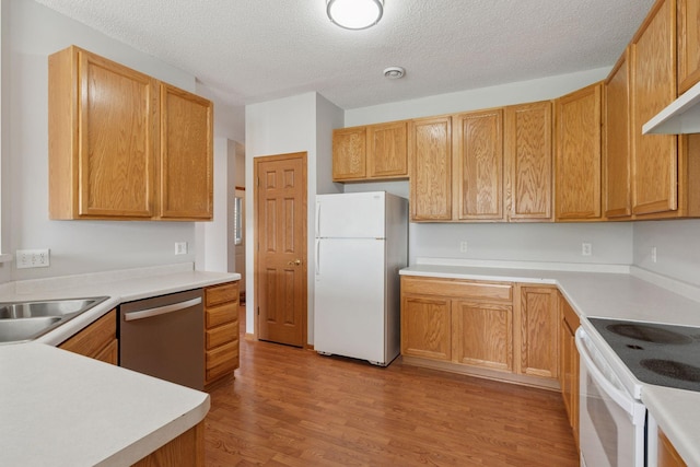 1848 111th Ave NE, Blaine, MN 55449 - kitchen featuring white appliances, light wood-style floors, a textured ceiling, a sink, and light countertops