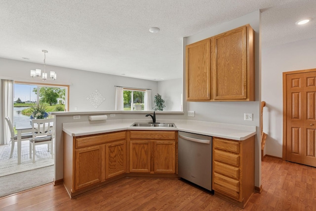 1848 111th Ave NE, Blaine, MN 55449 - kitchen featuring dishwasher, a sink, light countertops, light wood-type flooring, and a textured ceiling