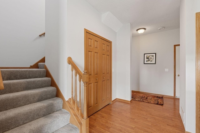 1848 111th Ave NE, Blaine, MN 55449 - foyer entrance with light wood finished floors, stairs, baseboards, and a textured ceiling