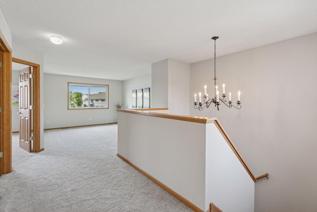 1848 111th Ave NE, Blaine, MN 55449 - corridor featuring an upstairs landing, carpet flooring, a chandelier, baseboards, and a textured ceiling