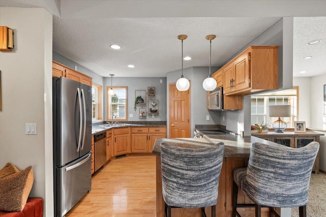 1107 Golden Way NW, Isanti, MN 55040 - kitchen featuring appliances with stainless steel finishes, a peninsula, a sink, recessed lighting, and pendant lighting