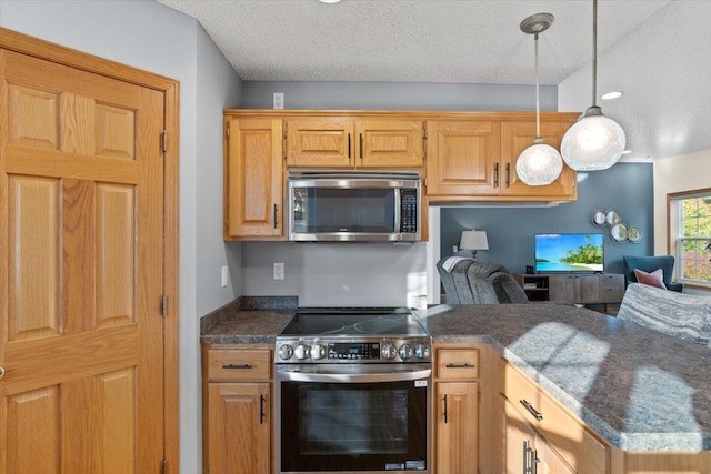 1107 Golden Way NW, Isanti, MN 55040 - kitchen featuring appliances with stainless steel finishes, dark countertops, a peninsula, open floor plan, and decorative light fixtures