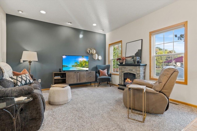 1107 Golden Way NW, Isanti, MN 55040 - carpeted living room with baseboards, healthy amount of natural light, a stone fireplace, recessed lighting, and a textured ceiling