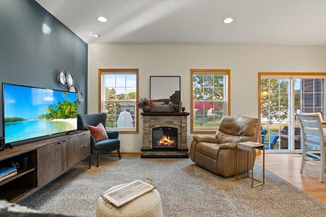 1107 Golden Way NW, Isanti, MN 55040 - living area with a textured ceiling, plenty of natural light, a fireplace, recessed lighting, and wood finished floors