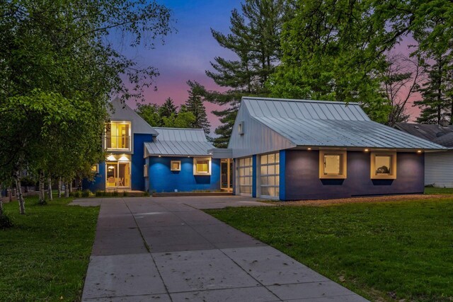 303 77th St, Chanhassen, MN 55317 - view of front facade with a standing seam roof, driveway, metal roof, a front yard, and an attached garage