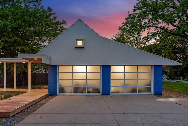 303 77th St, Chanhassen, MN 55317 - garage at dusk featuring driveway