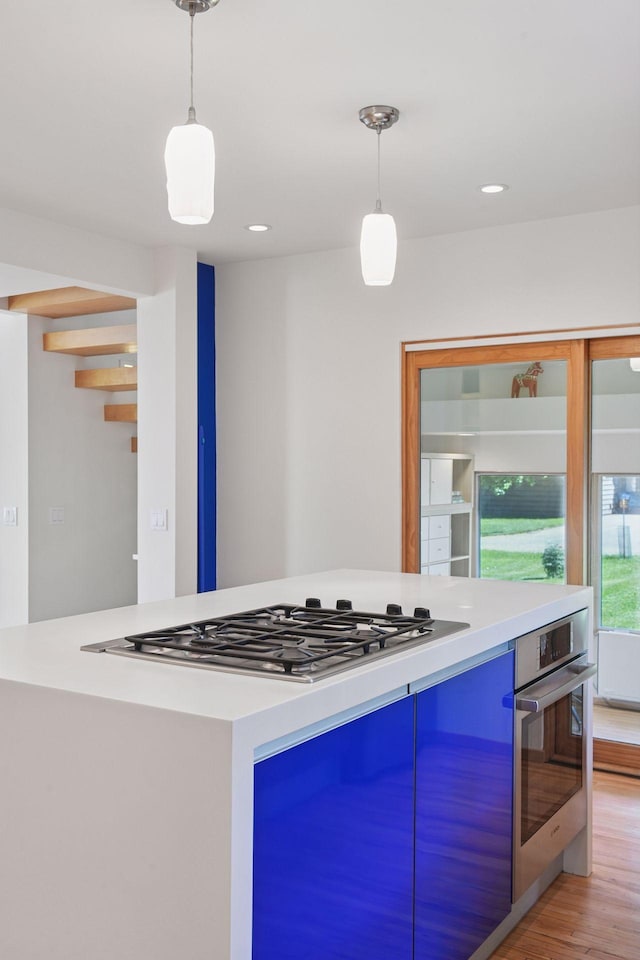 303 77th St, Chanhassen, MN 55317 - kitchen featuring appliances with stainless steel finishes, light wood-type flooring, hanging light fixtures, light countertops, and blue cabinetry
