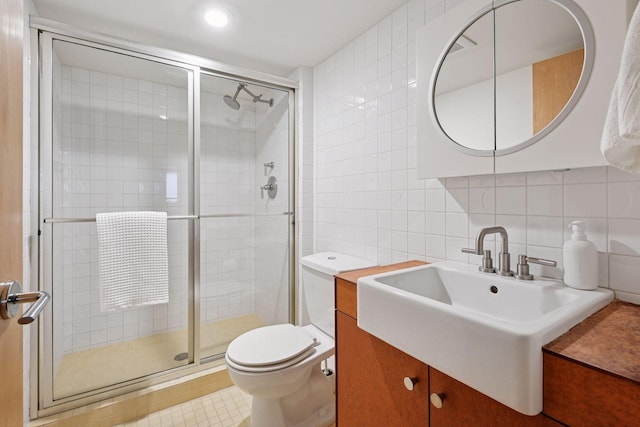 303 77th St, Chanhassen, MN 55317 - bathroom with tile walls, toilet, a shower stall, decorative backsplash, and vanity