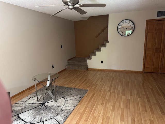 8942 Underwood Ln N, Maple Grove, MN 55369 - unfurnished living room with ceiling fan, stairs, light wood finished floors, a textured ceiling, and baseboards