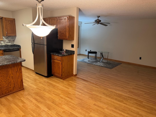 8942 Underwood Ln N, Maple Grove, MN 55369 - kitchen featuring stainless steel appliances, light wood finished floors, dark countertops, ceiling fan, and a textured ceiling