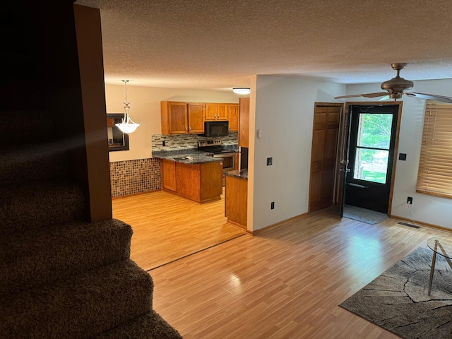 8942 Underwood Ln N, Maple Grove, MN 55369 - kitchen featuring black microwave, electric stove, brown cabinetry, light wood-style flooring, and a textured ceiling