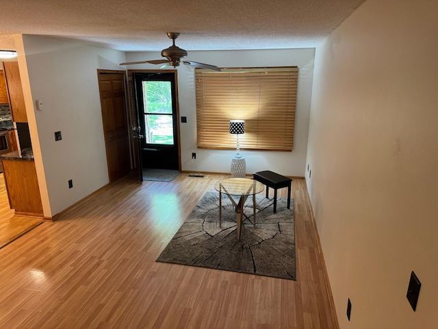 8942 Underwood Ln N, Maple Grove, MN 55369 - dining space with light wood-type flooring, a ceiling fan, baseboards, and a textured ceiling
