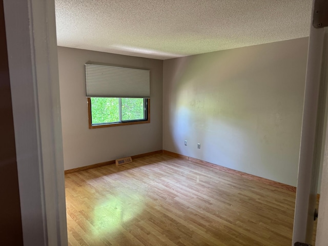 8942 Underwood Ln N, Maple Grove, MN 55369 - empty room with wood finished floors, a textured ceiling, and baseboards