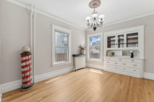 1744 Marshall Ave, Saint Paul, MN 55104 - dining area featuring a chandelier, light wood-style floors, radiator, ornamental molding, and baseboards
