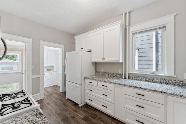1744 Marshall Ave, Saint Paul, MN 55104 - kitchen with freestanding refrigerator, dark wood-style flooring, white cabinets, range, and light stone counters