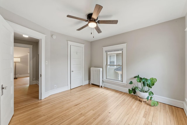 1744 Marshall Ave, Saint Paul, MN 55104 - unfurnished bedroom with radiator heating unit, baseboards, light wood-type flooring, and a ceiling fan