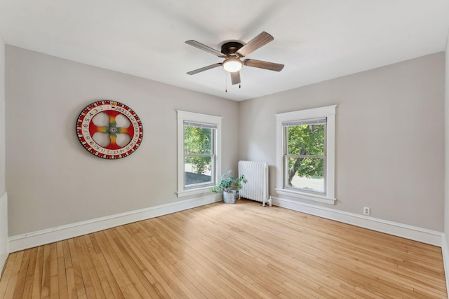 1744 Marshall Ave, Saint Paul, MN 55104 - unfurnished room featuring radiator heating unit, baseboards, wood-type flooring, and ceiling fan