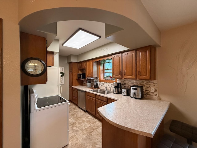 288 Locust St, Dawson, MN 56232 - kitchen featuring stainless steel appliances, a peninsula, a sink, light countertops, and brown cabinets