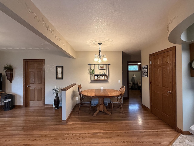 288 Locust St, Dawson, MN 56232 - dining area with light wood-type flooring, a chandelier, a textured ceiling, and baseboards