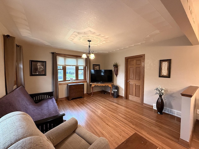 288 Locust St, Dawson, MN 56232 - living room featuring a chandelier, light wood-style floors, a textured ceiling, and baseboards