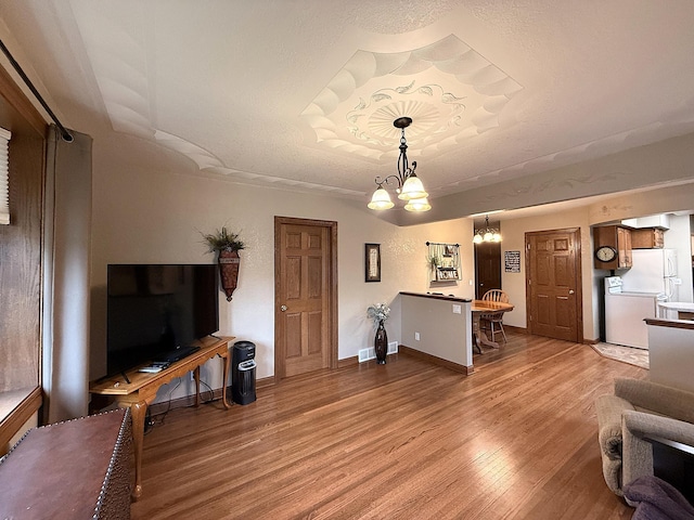 288 Locust St, Dawson, MN 56232 - living room featuring wood finished floors, a chandelier, and baseboards