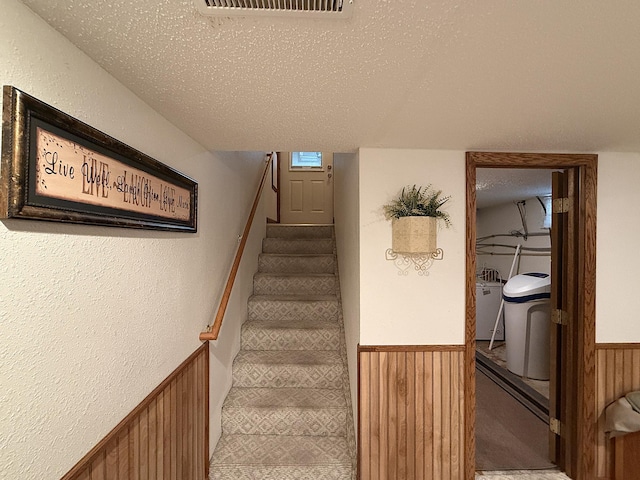 288 Locust St, Dawson, MN 56232 - stairway with a wainscoted wall, a textured ceiling, wooden walls, carpet floors, and a textured wall