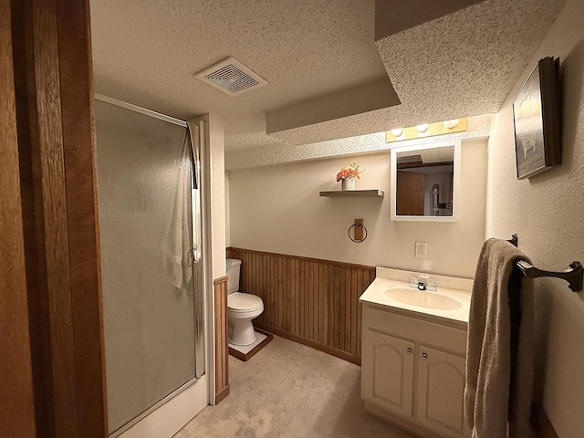 288 Locust St, Dawson, MN 56232 - full bath featuring a textured ceiling, vanity, a stall shower, toilet, and wainscoting