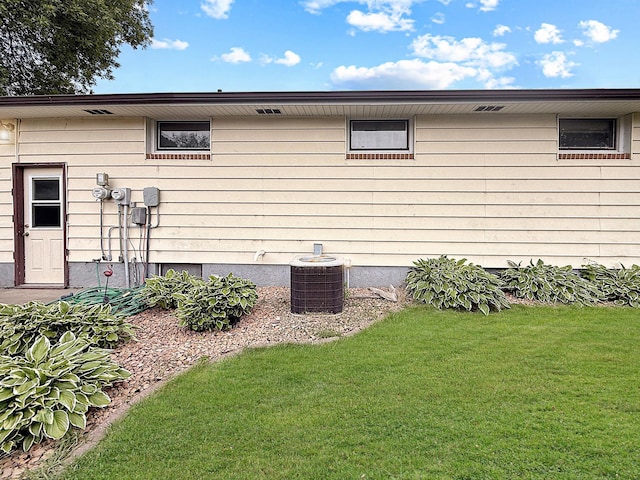 288 Locust St, Dawson, MN 56232 - view of home's exterior featuring central AC unit and a yard