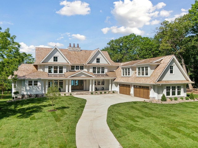2475 Dunwoody Ave, Orono, MN 55391 - shingle-style home featuring concrete driveway, a garage, covered porch, a front yard, and a chimney