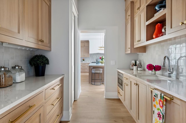 2475 Dunwoody Ave, Orono, MN 55391 - kitchen with a sink, tasteful backsplash, light wood-style floors, and light brown cabinets